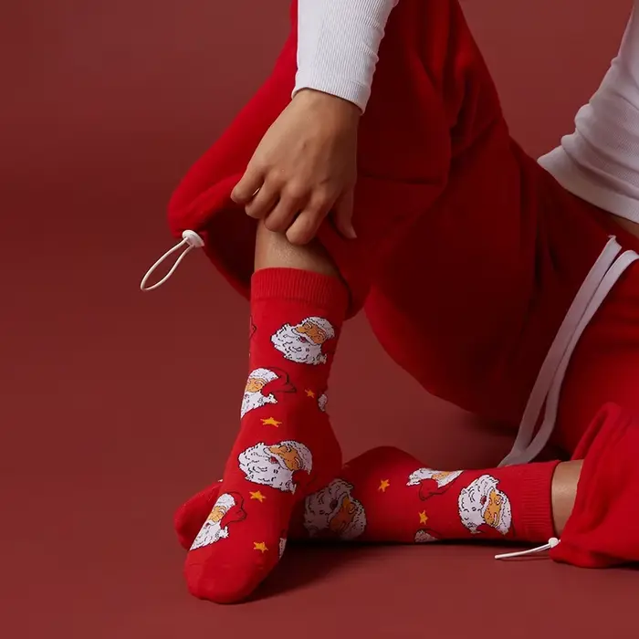 1 paire de chaussettes unisexes avec semelles rouges festives ornées de motifs Père Noël et d'étoiles